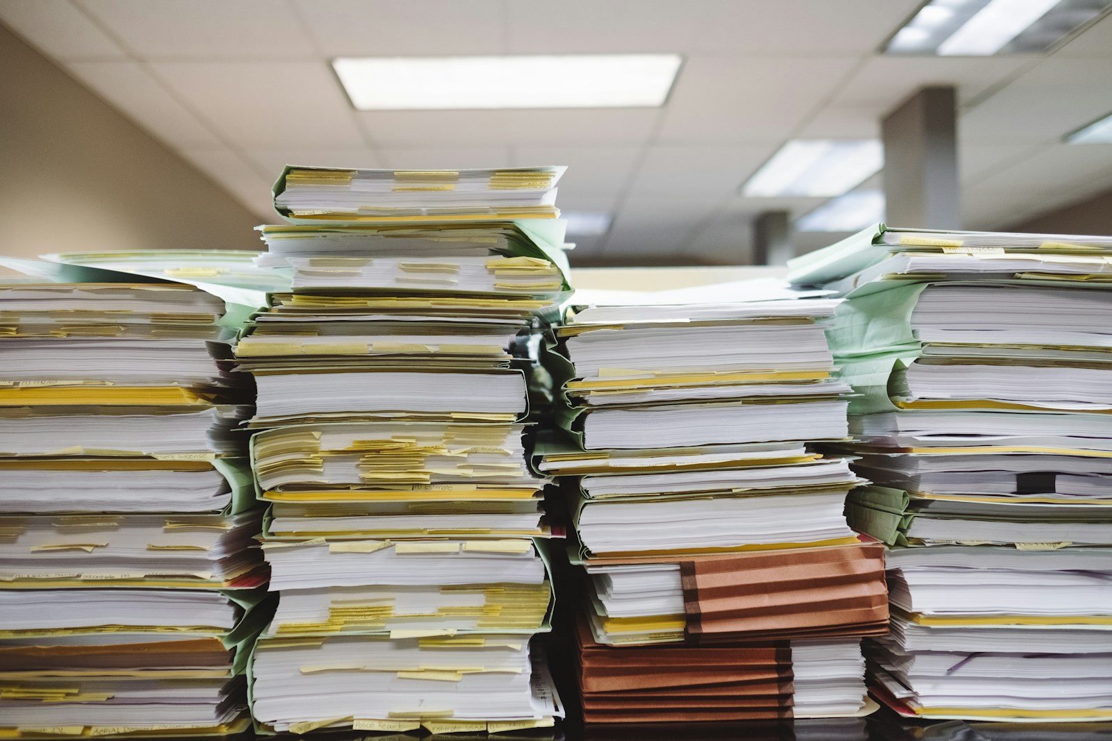 Stacks of paper tax files representing an overloaded tax filing system